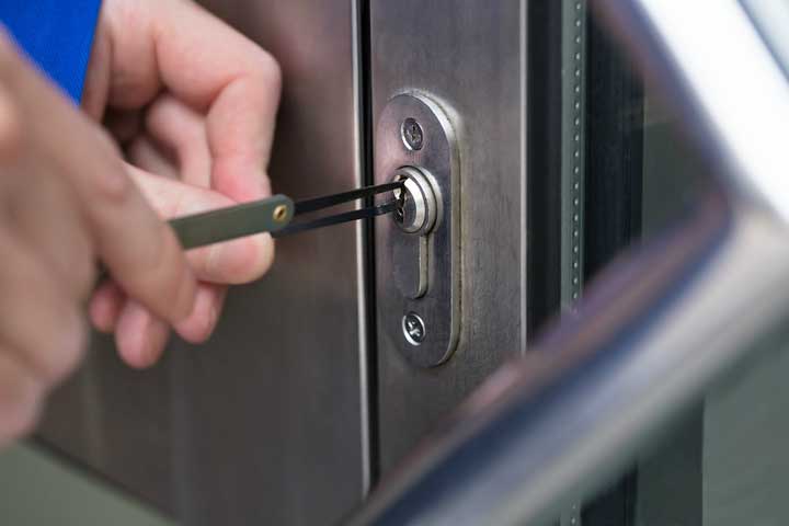 Commercial locksmith picking a lock on a business door in Belfast